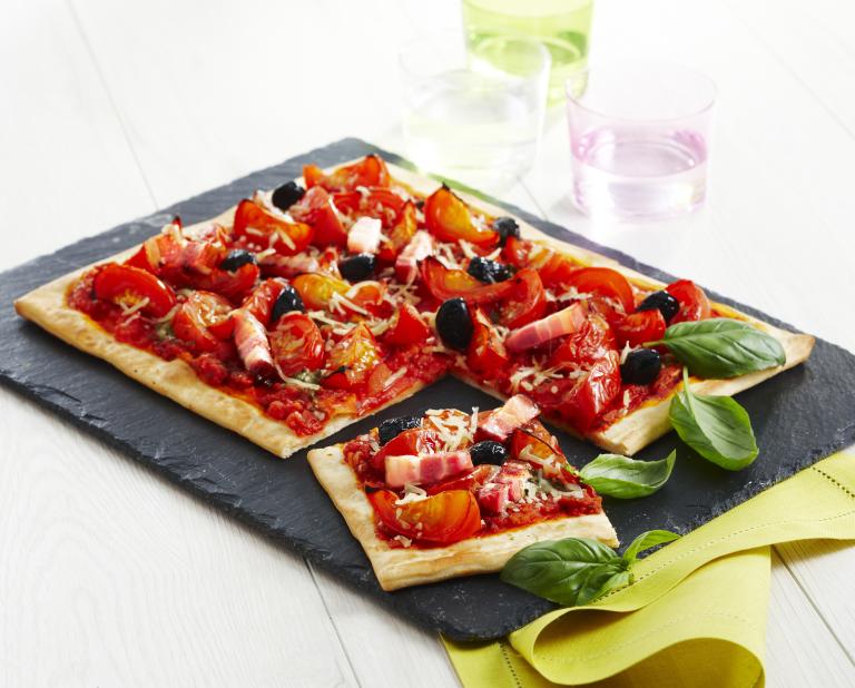 Pizza aux tomates, lardons, olives et pesto